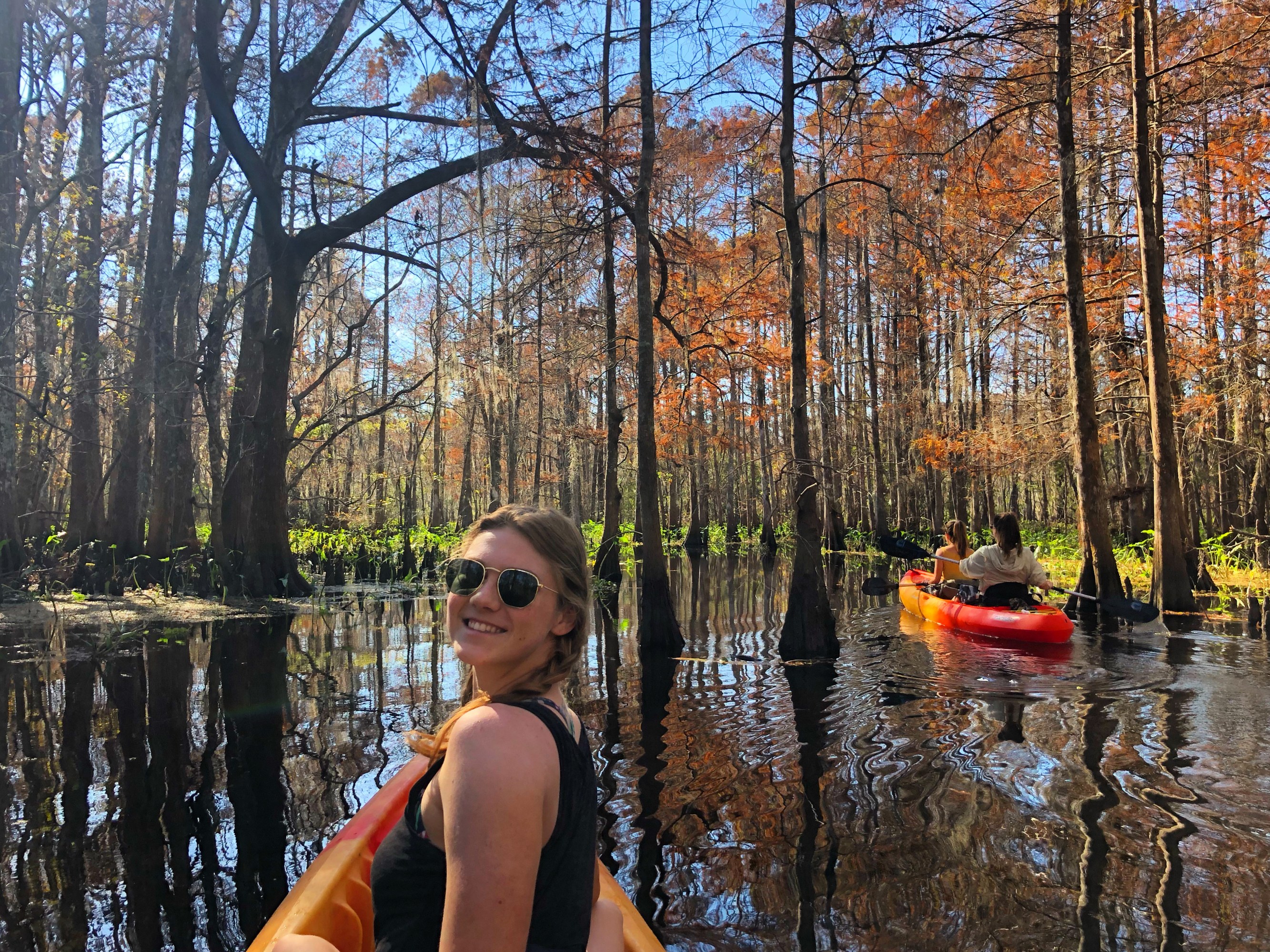 Smiling kayaker taking a selfie among autumn cypress trees on a Louisiana swamp tour