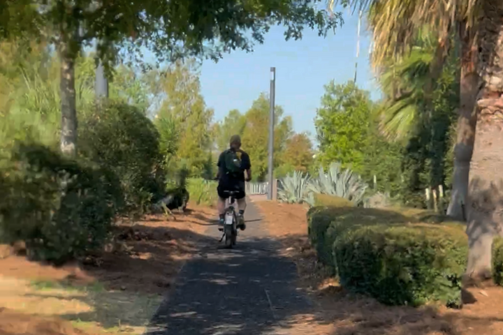 a man riding a bike down a dirt road